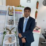 Arun Gee, Chairman of Excellency Group of Companies, stands confidently in a boardroom setting, exuding leadership and determination